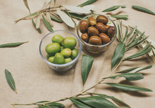 Due varietà di olive con foglia di olivo