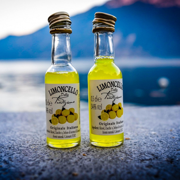 Bottigliette di limoncello con mare sullo sfondo