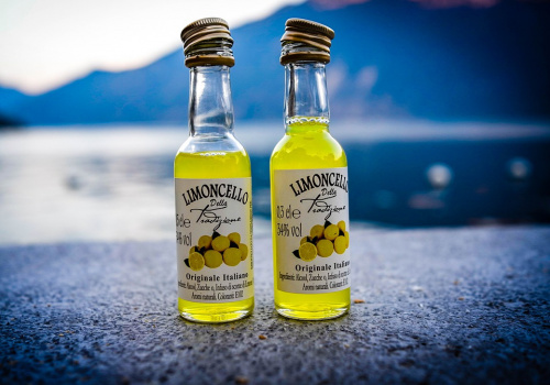 Bottigliette di limoncello con mare sullo sfondo